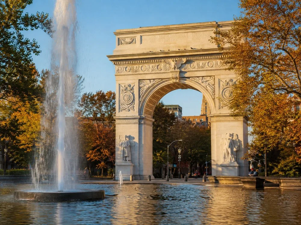 The marble Washington Square Arch seen from the fountain in autumn light